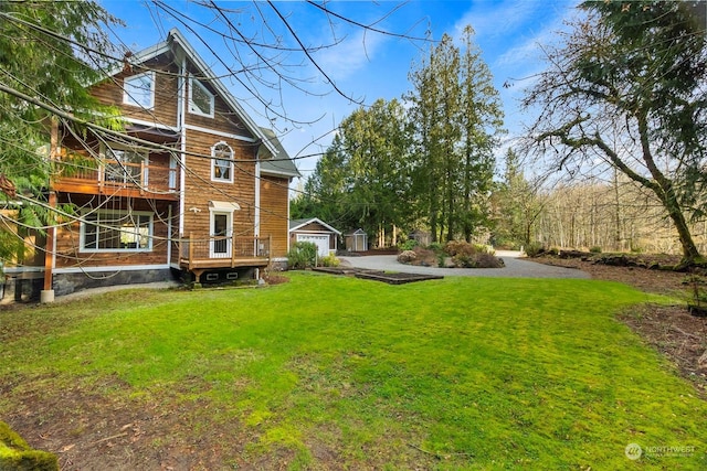 back of property with an outbuilding, a lawn, and a garage