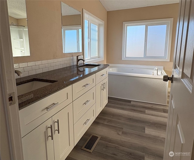 bathroom featuring vanity, a bathing tub, a textured ceiling, and hardwood / wood-style floors