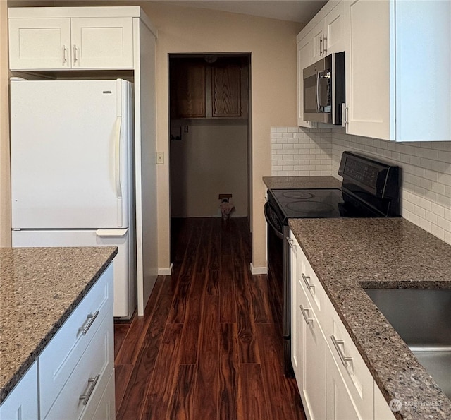 kitchen with backsplash, black electric range, stone counters, white cabinets, and white refrigerator