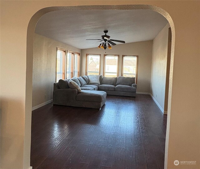 unfurnished living room with dark wood-type flooring, ceiling fan, and lofted ceiling