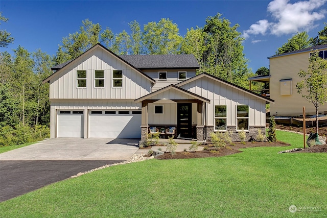 modern farmhouse featuring a front yard, covered porch, and a garage