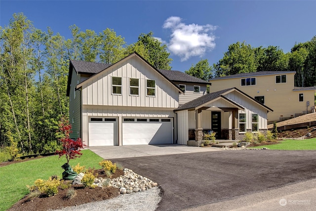 view of front of house with a front yard, covered porch, and a garage