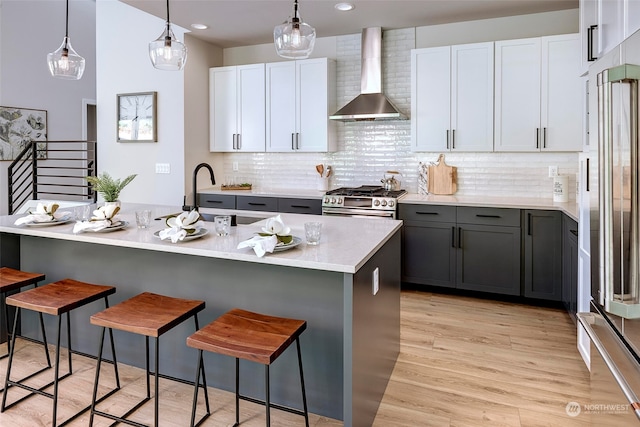 kitchen with wall chimney range hood, gray cabinets, white cabinetry, and stainless steel appliances