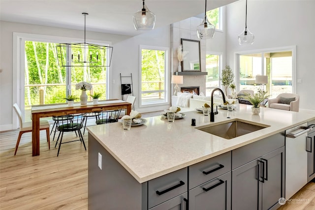 kitchen featuring decorative light fixtures, light wood-type flooring, sink, and gray cabinets