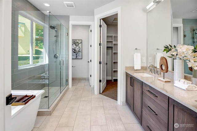 bathroom with a wealth of natural light, an enclosed shower, and vanity