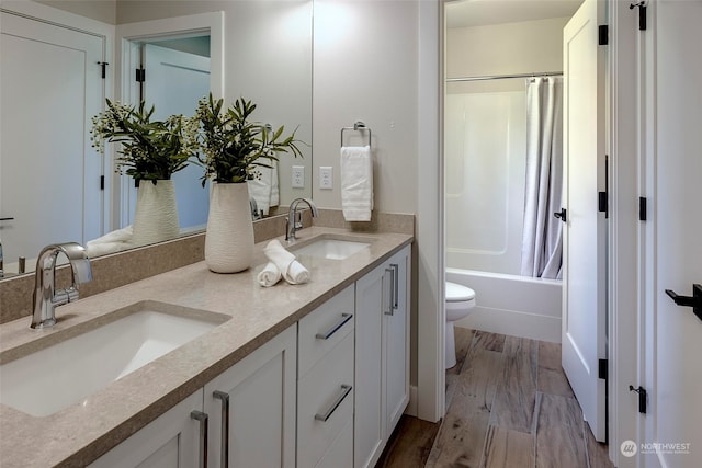 full bathroom with hardwood / wood-style flooring, toilet, vanity, and shower / bath combination with curtain