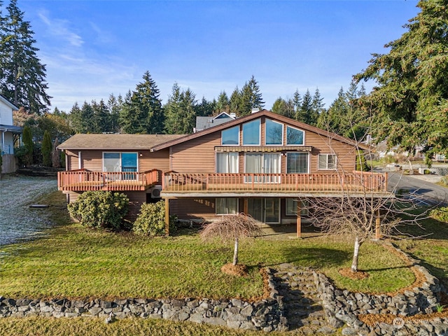 back of house featuring a lawn and a wooden deck