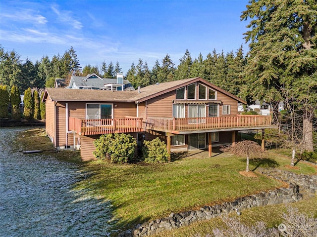 back of property with a wooden deck and a yard