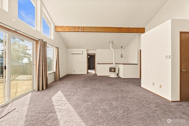 unfurnished living room featuring beamed ceiling, an AC wall unit, carpet floors, a wood stove, and high vaulted ceiling