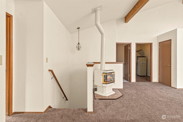 basement with a wood stove, carpet flooring, and water heater