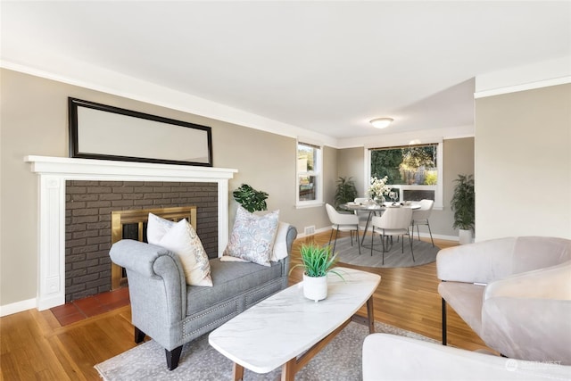 living room featuring a brick fireplace and hardwood / wood-style floors