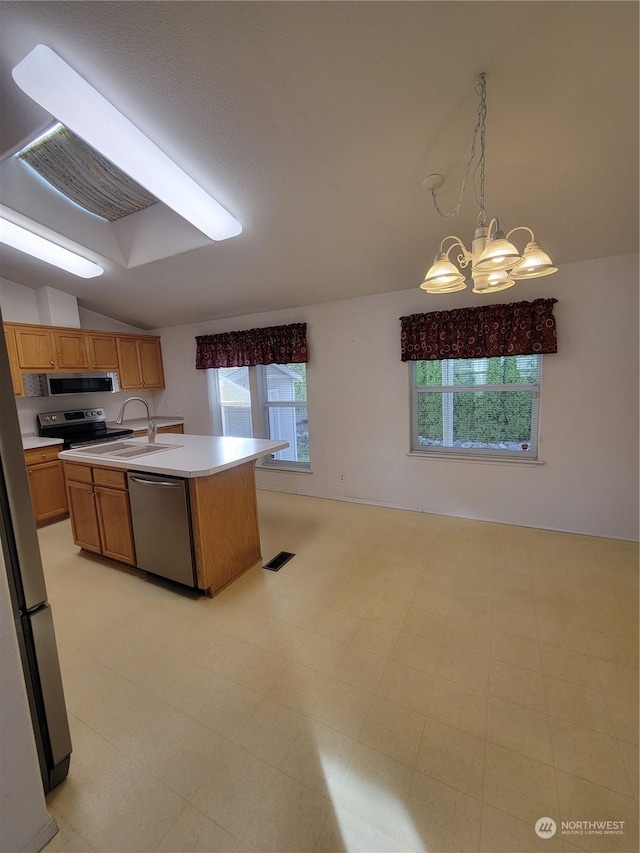 kitchen featuring lofted ceiling, sink, pendant lighting, stainless steel appliances, and a center island with sink