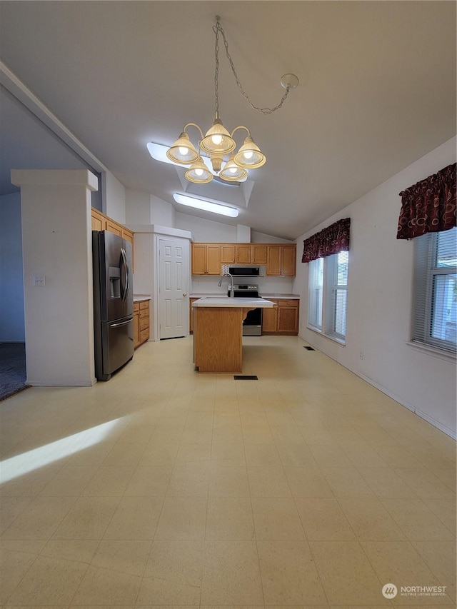 kitchen featuring pendant lighting, lofted ceiling, stainless steel appliances, a kitchen island, and a chandelier