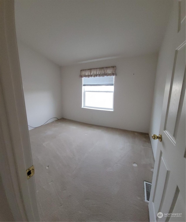 spare room featuring light colored carpet