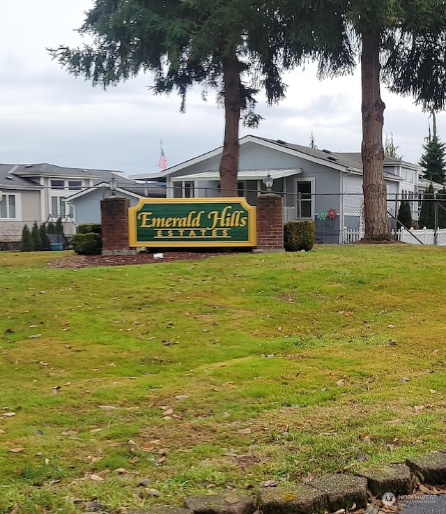 community / neighborhood sign featuring a yard