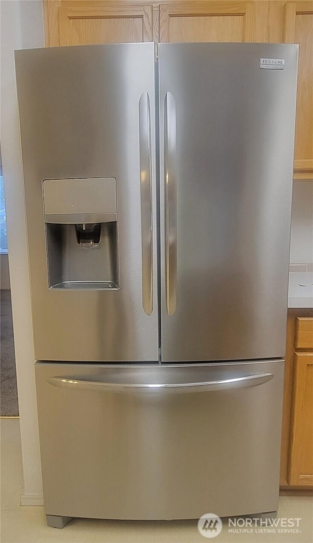 room details with stainless steel fridge and light brown cabinets