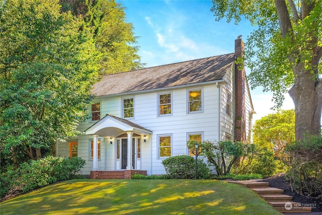 colonial inspired home with a front lawn