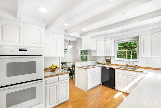 kitchen with decorative light fixtures, dishwasher, white double oven, sink, and white cabinetry