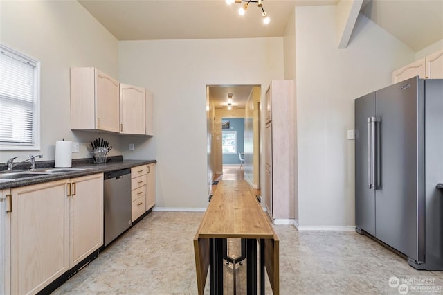 kitchen featuring light brown cabinetry, sink, appliances with stainless steel finishes, and a healthy amount of sunlight