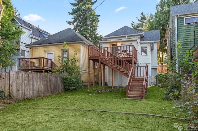 back of property featuring a deck and a yard