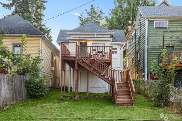 rear view of house featuring a deck and a yard