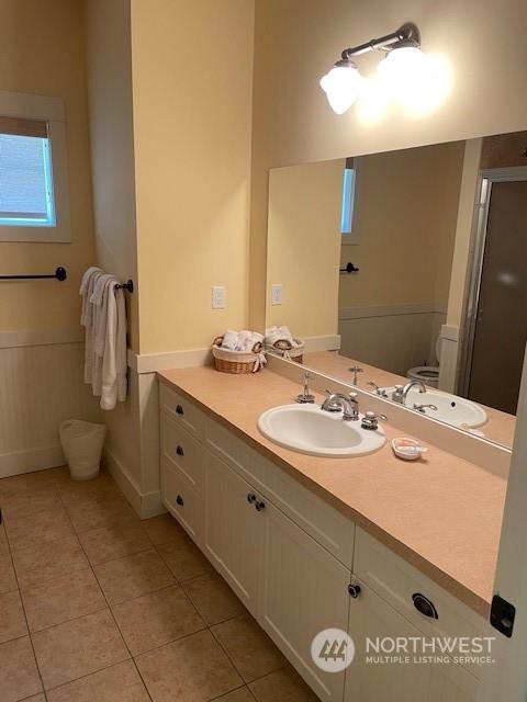 bathroom featuring vanity, tile patterned floors, and toilet