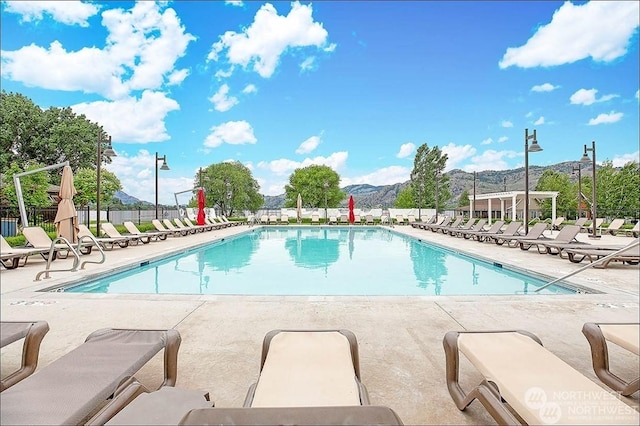 view of swimming pool with a mountain view and a patio area