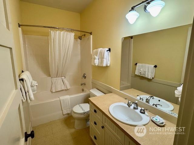 full bathroom featuring vanity, shower / tub combo with curtain, tile patterned floors, and toilet