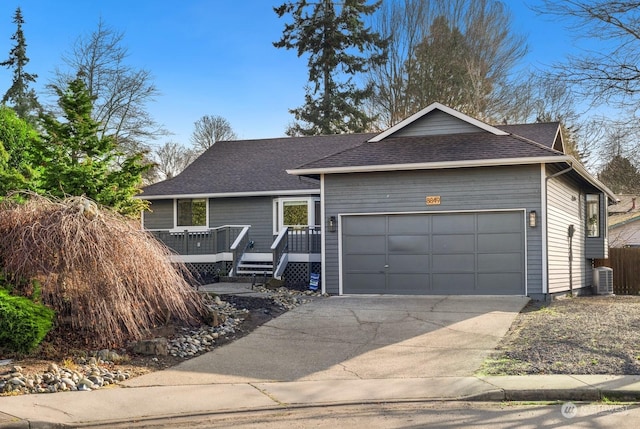 ranch-style house with central AC unit, a garage, and a wooden deck