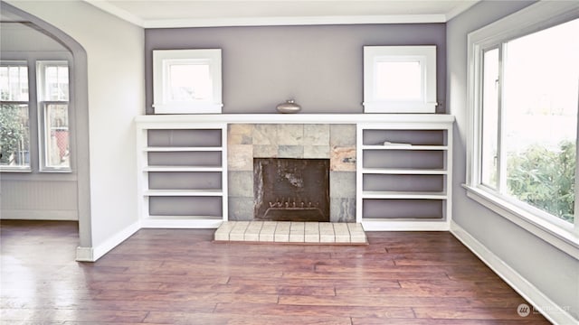 unfurnished living room featuring a fireplace, dark hardwood / wood-style flooring, and crown molding