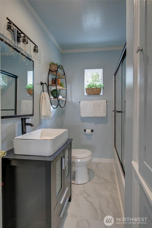 full bath featuring toilet, marble finish floor, ornamental molding, baseboards, and vanity