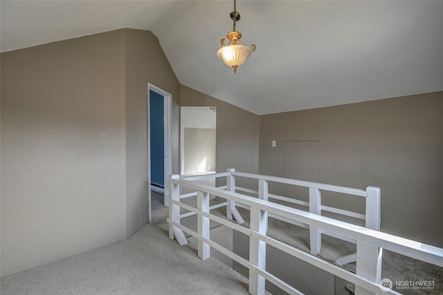 corridor with lofted ceiling and carpet