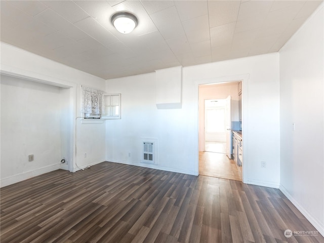 laundry room with dark hardwood / wood-style flooring and heating unit