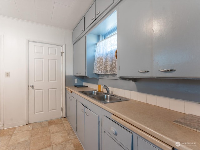 kitchen with sink, gray cabinets, and ornamental molding