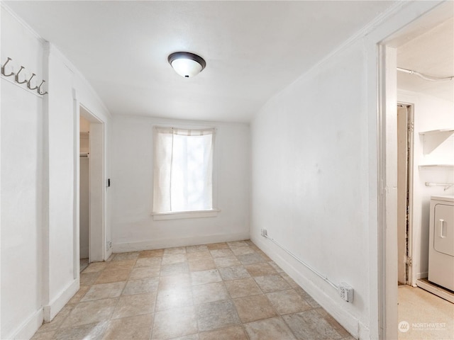 spare room with crown molding and washer / dryer