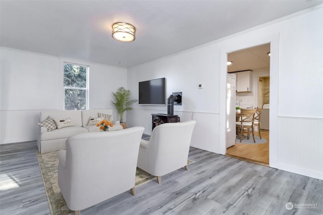 living room with washer / dryer and light wood-type flooring