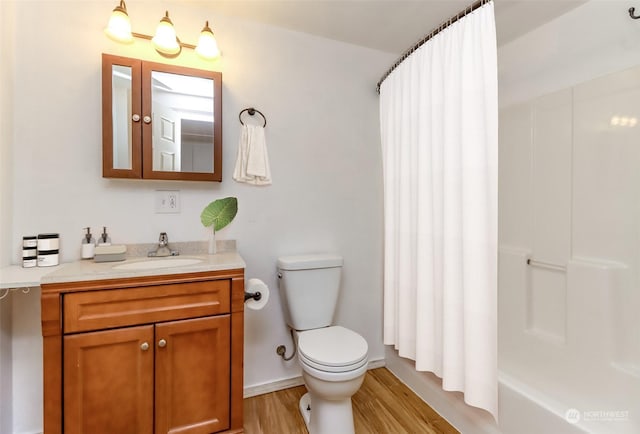 full bathroom with vanity, hardwood / wood-style floors, shower / bath combo with shower curtain, and toilet