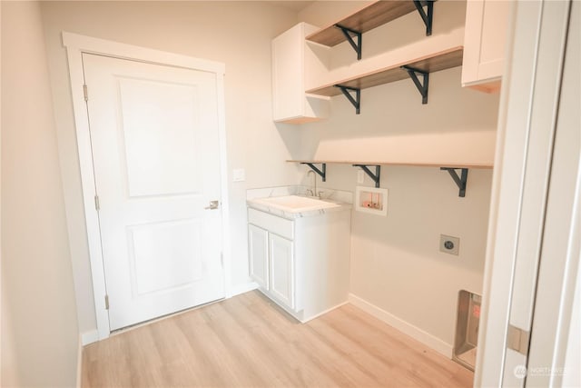 laundry area featuring sink, cabinets, hookup for a washing machine, electric dryer hookup, and light hardwood / wood-style floors