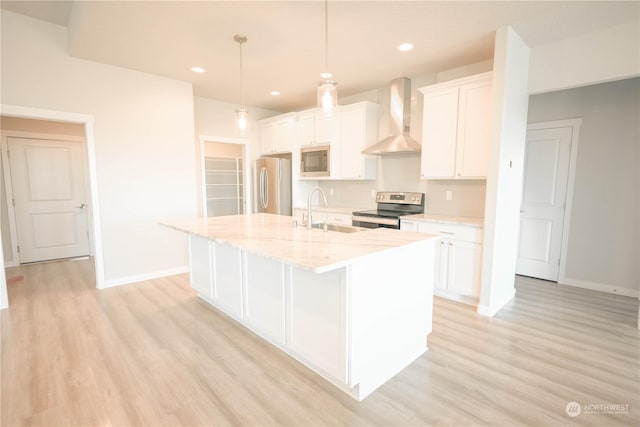 kitchen with wall chimney exhaust hood, sink, decorative light fixtures, stainless steel appliances, and white cabinets