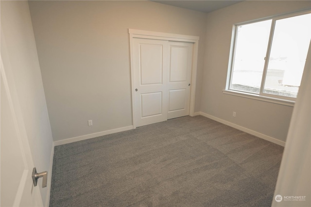 unfurnished bedroom featuring carpet floors and a closet