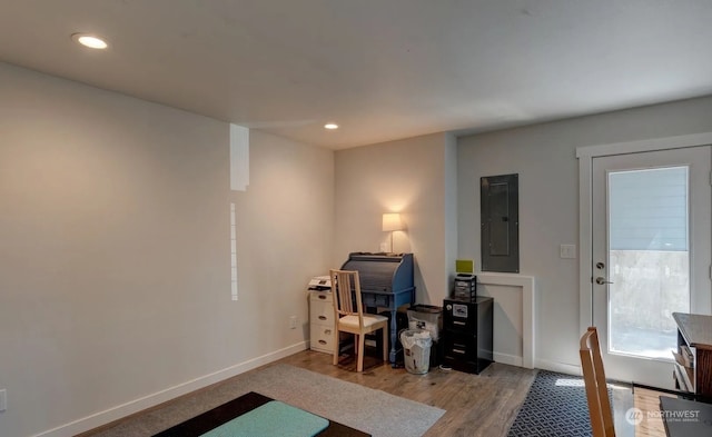 office space with electric panel and wood-type flooring