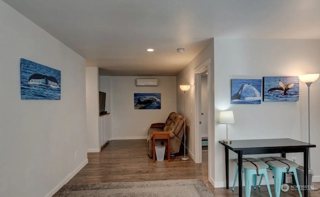 corridor with a wall unit AC and hardwood / wood-style floors