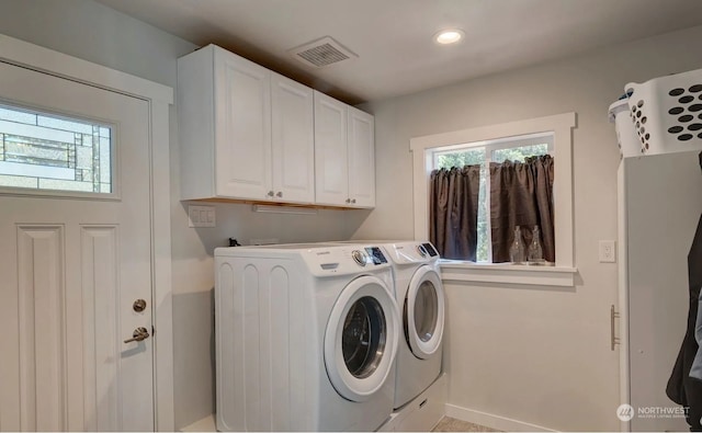 laundry area with washer and dryer and cabinets