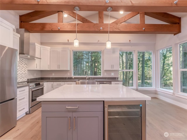 kitchen featuring light stone countertops, pendant lighting, appliances with stainless steel finishes, wall chimney exhaust hood, and wine cooler