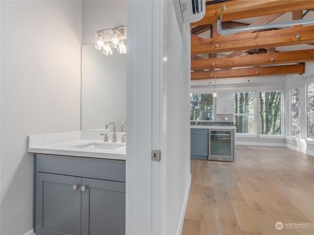 bathroom with vanity, hardwood / wood-style flooring, beam ceiling, and beverage cooler