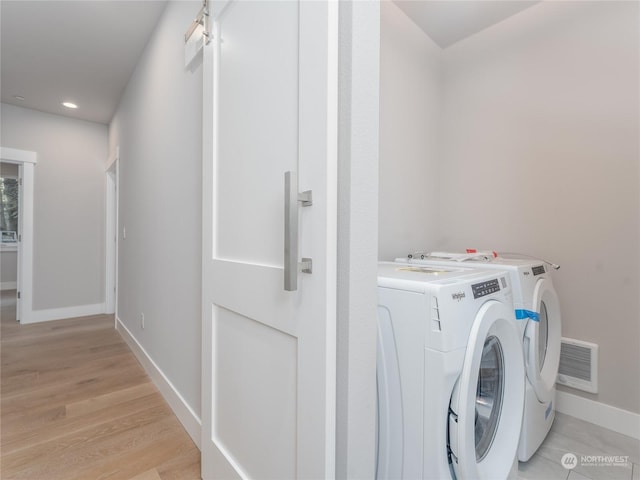 laundry room with light hardwood / wood-style floors and separate washer and dryer