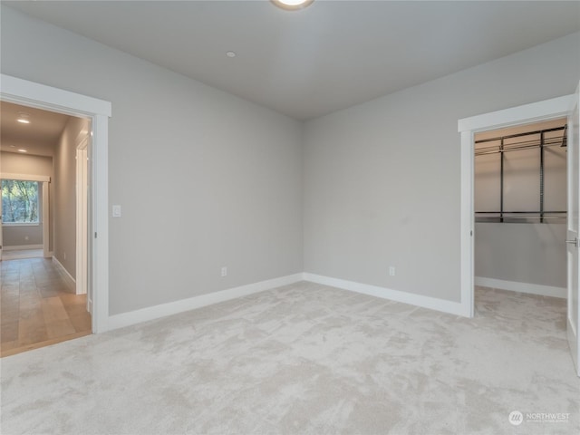 unfurnished bedroom with a closet and light colored carpet