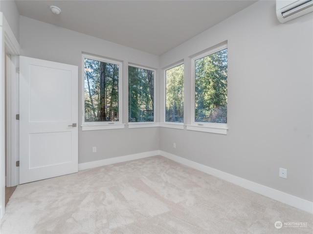 spare room with light colored carpet and a wall mounted air conditioner