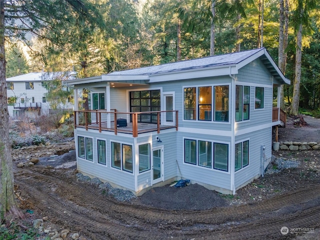 rear view of property with a balcony and a sunroom