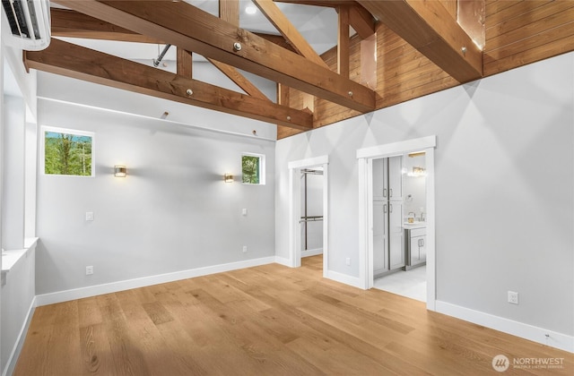 7339 Moon Valley Rd SE, North Bend, WA 98045 - empty room with beam ceiling, a wealth of natural light, baseboards, and wood finished floors
